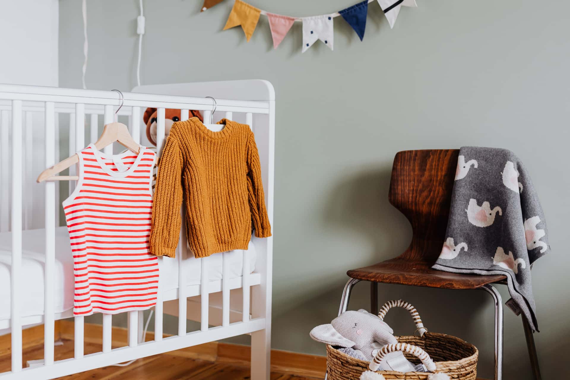 A calm, softly lit nursery with a crib and glider